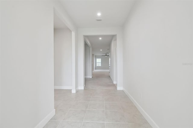 corridor with recessed lighting, baseboards, and light tile patterned floors