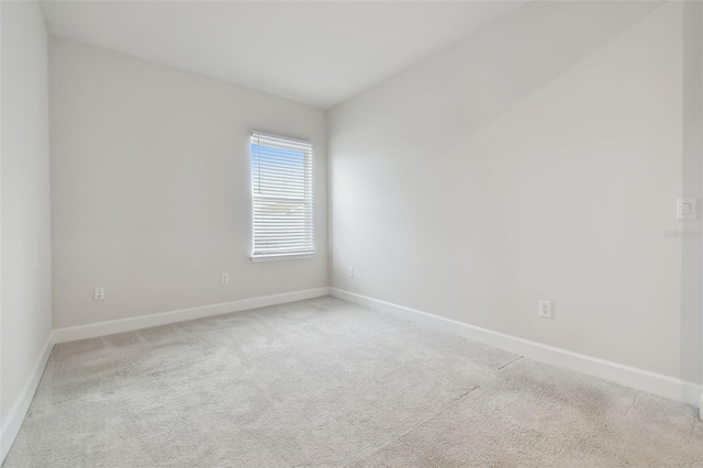 carpeted empty room featuring baseboards