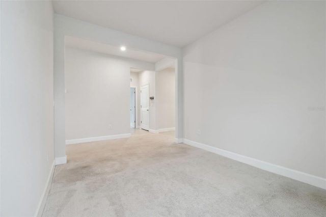 empty room with light colored carpet and baseboards