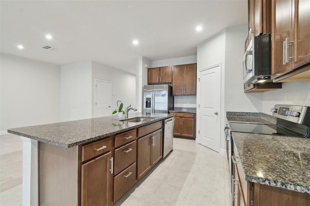 kitchen with a center island with sink, stainless steel appliances, recessed lighting, visible vents, and a sink