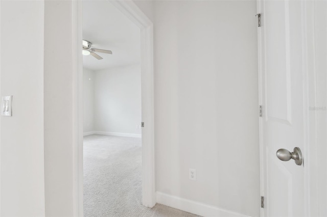 corridor featuring carpet flooring and baseboards