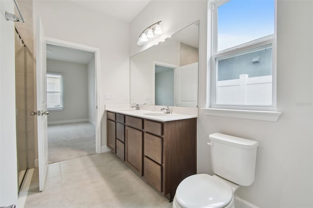 full bath with double vanity, a sink, toilet, and baseboards