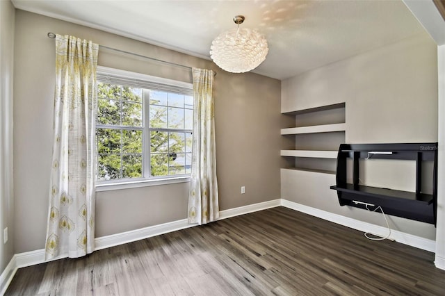 unfurnished living room with dark wood-type flooring and baseboards