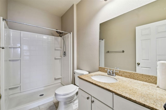 bathroom featuring toilet, tile patterned floors, a shower, and vanity