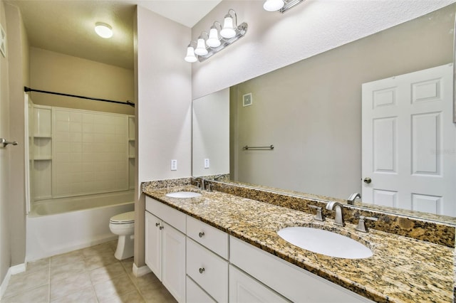 bathroom with double vanity, a sink, toilet, and tile patterned floors