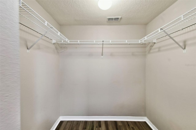 walk in closet with visible vents and wood finished floors