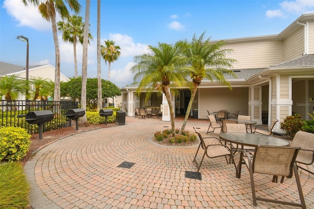 view of patio featuring outdoor dining space, grilling area, and fence