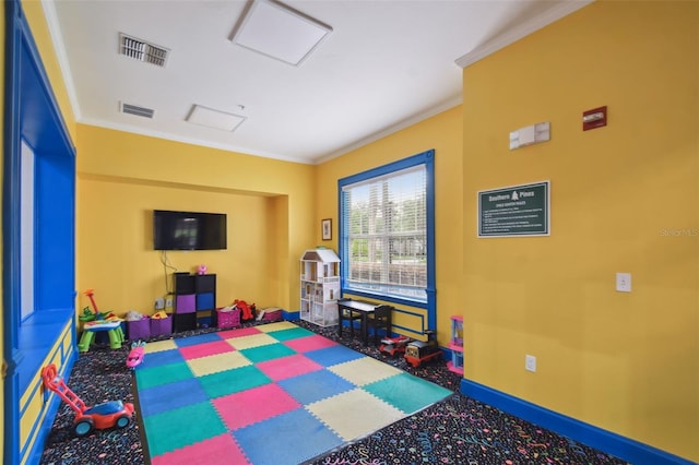 playroom with baseboards, visible vents, crown molding, and carpet flooring