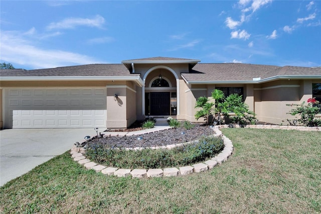 view of front of property featuring a garage, a front lawn, concrete driveway, and stucco siding