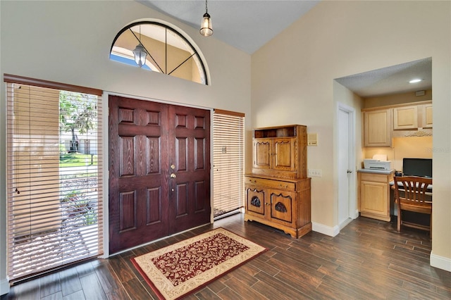 entryway with high vaulted ceiling, wood finish floors, and baseboards