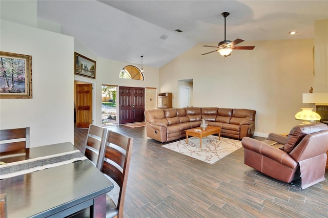 living area featuring high vaulted ceiling, wood finished floors, visible vents, baseboards, and a ceiling fan