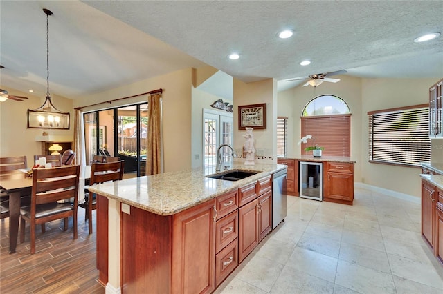 kitchen with wine cooler, a center island with sink, a ceiling fan, a sink, and dishwasher