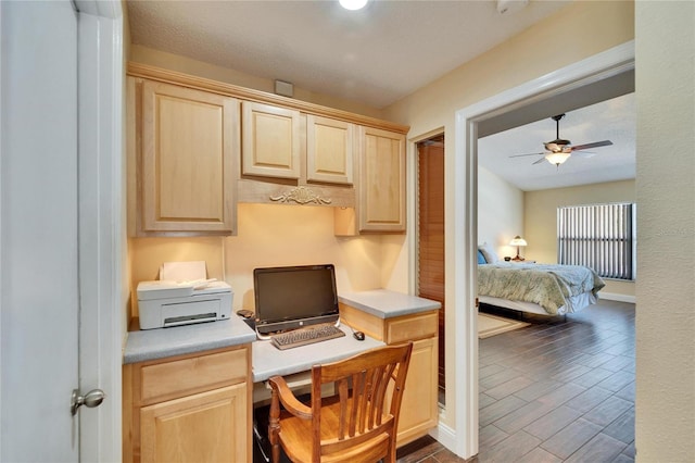 office area featuring a ceiling fan, baseboards, and wood finished floors