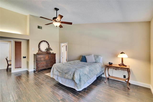 bedroom with lofted ceiling, wood finish floors, visible vents, and baseboards