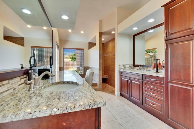 full bathroom featuring tile patterned flooring, two vanities, walk in shower, and a sink