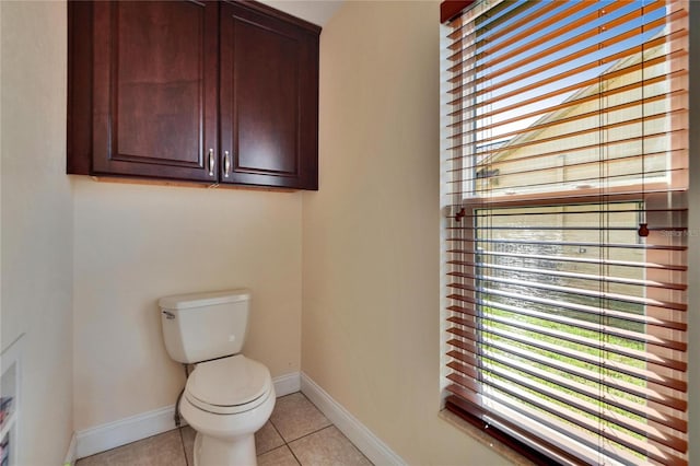 bathroom with baseboards, toilet, and tile patterned floors