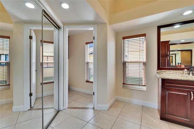 bathroom featuring baseboards, tile patterned flooring, vanity, and recessed lighting