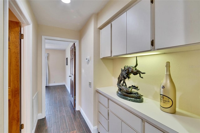 hallway with baseboards and wood finish floors