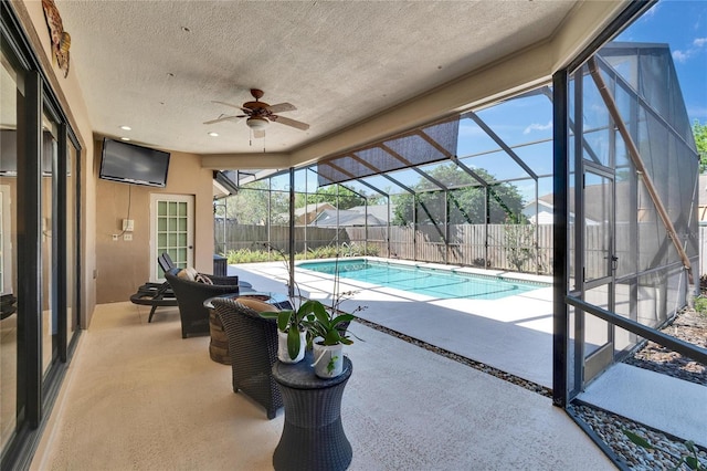 view of swimming pool with a ceiling fan, a lanai, a fenced backyard, and a patio