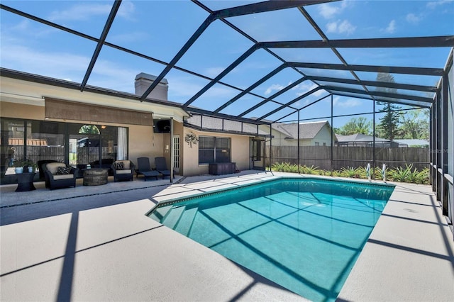 view of swimming pool featuring glass enclosure, a patio area, fence, and a fenced in pool