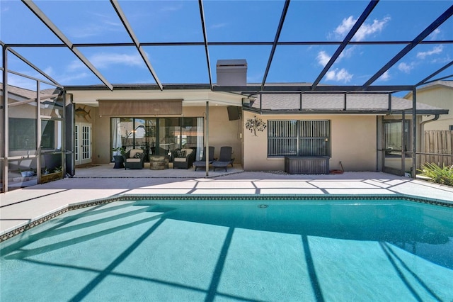 rear view of property with an outdoor pool, glass enclosure, a patio, and stucco siding