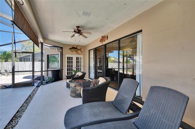 sunroom with a ceiling fan and french doors