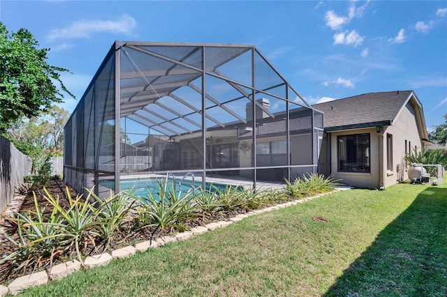 rear view of property featuring a fenced in pool, a fenced backyard, a lanai, a yard, and stucco siding