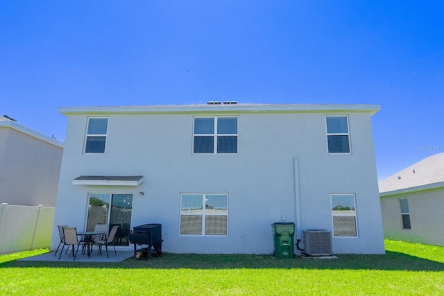 back of property featuring fence, central AC, stucco siding, a lawn, and a patio area