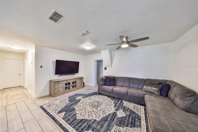 living area with visible vents, ceiling fan, and a textured ceiling