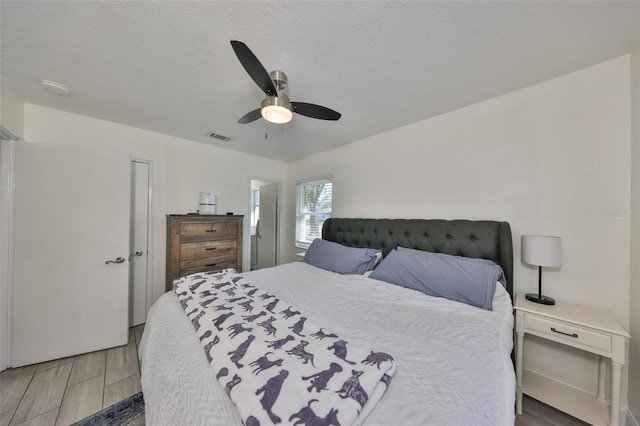 bedroom with visible vents, a ceiling fan, and wood finish floors