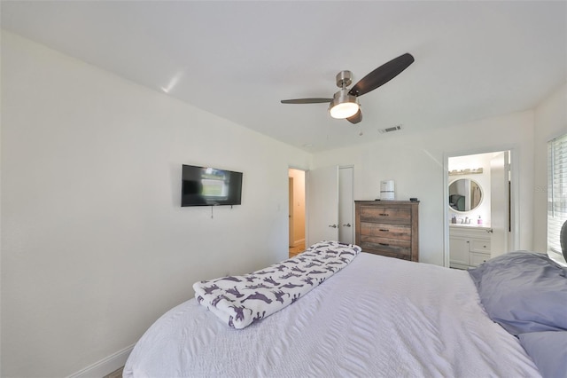 bedroom with visible vents, ceiling fan, baseboards, and ensuite bathroom