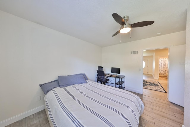 bedroom featuring baseboards, ceiling fan, visible vents, and light wood-style floors