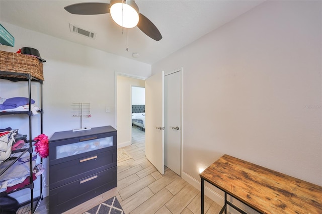 interior space featuring ceiling fan, baseboards, visible vents, and wood tiled floor