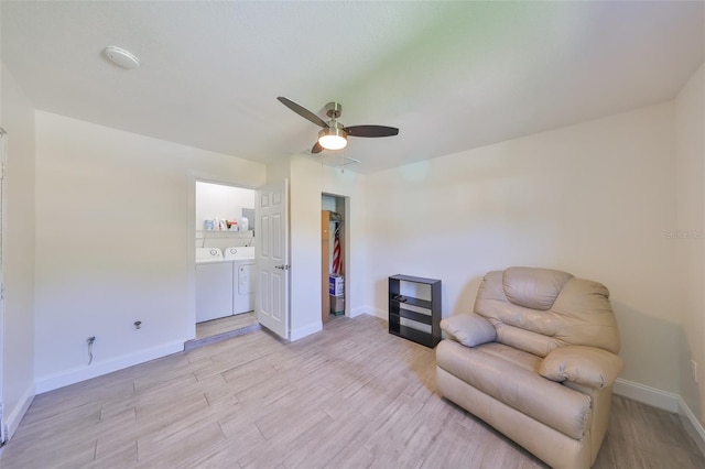 living area with light wood-style floors, baseboards, a ceiling fan, and independent washer and dryer