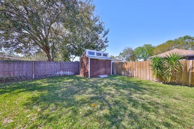 view of yard featuring an outbuilding, a fenced backyard, and a storage shed