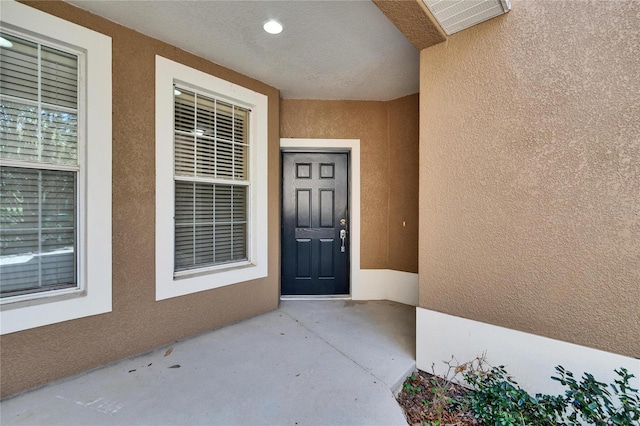 property entrance featuring visible vents and stucco siding