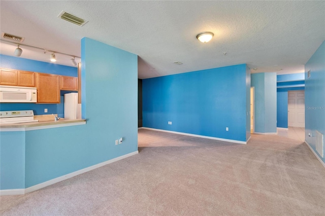 unfurnished living room with a textured ceiling, visible vents, and baseboards