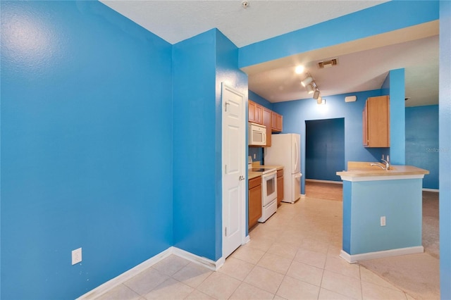 kitchen with white appliances, light countertops, visible vents, and baseboards