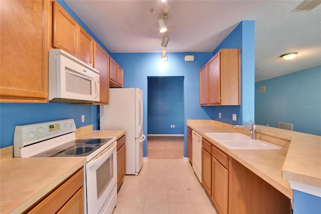 kitchen with light countertops, white appliances, a sink, and visible vents