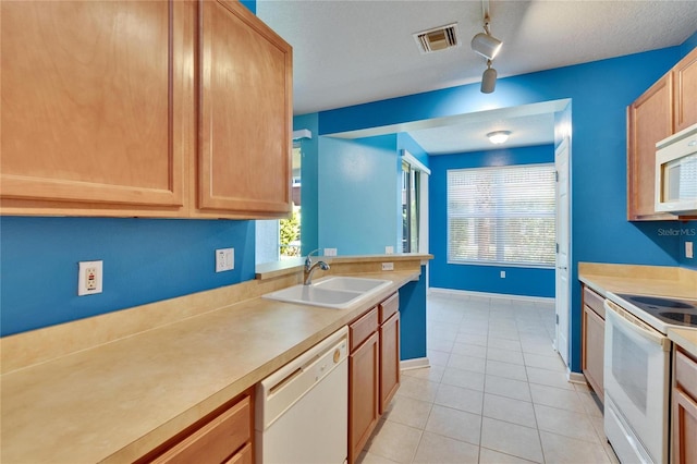 kitchen featuring white appliances, light tile patterned floors, visible vents, light countertops, and a sink