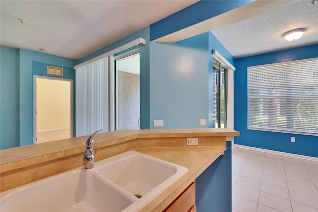 bathroom with a textured ceiling, vanity, and tile patterned floors