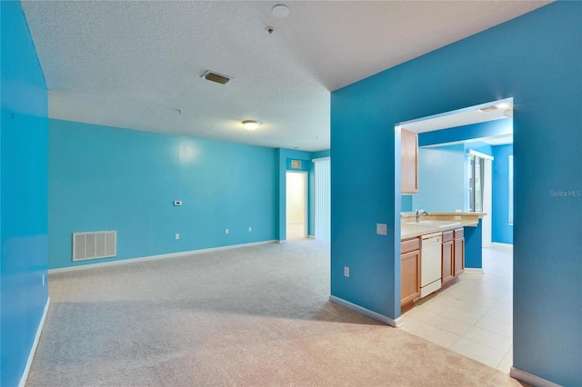 interior space featuring visible vents, a sink, light carpet, and a textured ceiling