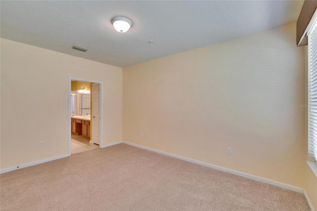 empty room featuring light carpet, baseboards, and visible vents