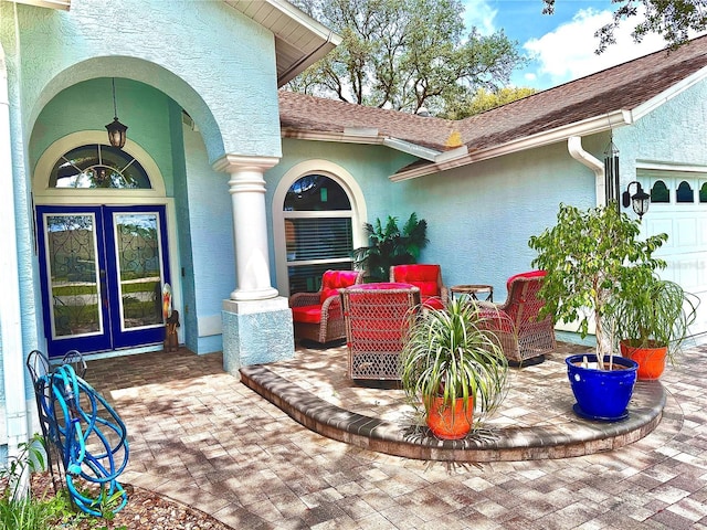 2069 Overbrook Ln, Spring Hill, FL 34606 - view of exterior entry with stucco siding, a garage, and a shingled roof