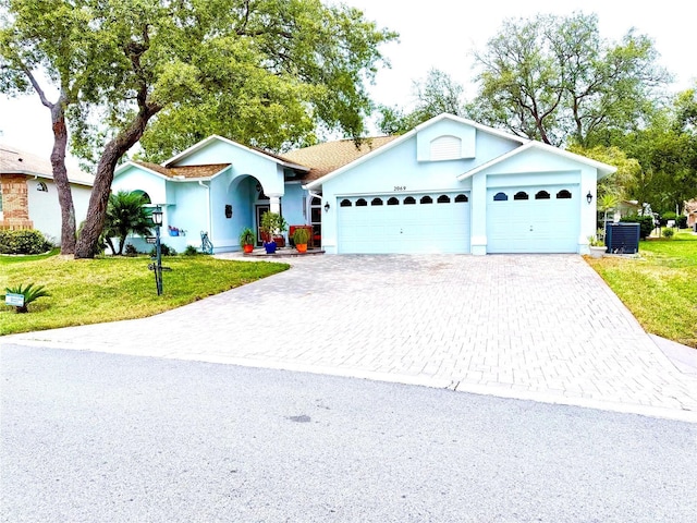 2069 Overbrook Ln, Spring Hill, FL 34606 - ranch-style house with decorative driveway, a garage, a front lawn, and stucco siding