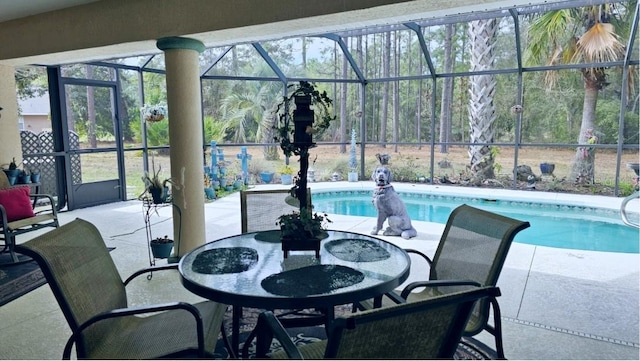 outdoor pool featuring glass enclosure and a patio area