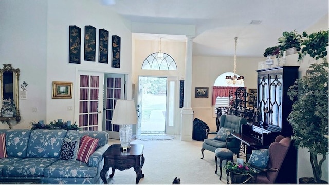 carpeted living area with a notable chandelier and a towering ceiling