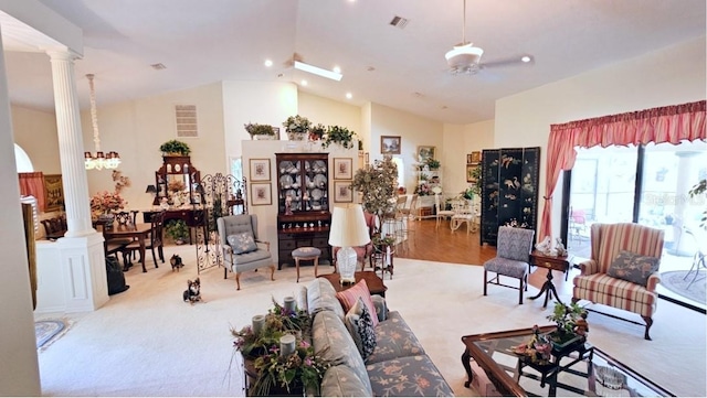 living room featuring vaulted ceiling, decorative columns, and visible vents