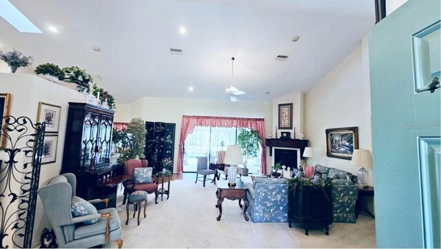 living room with a skylight, visible vents, and high vaulted ceiling