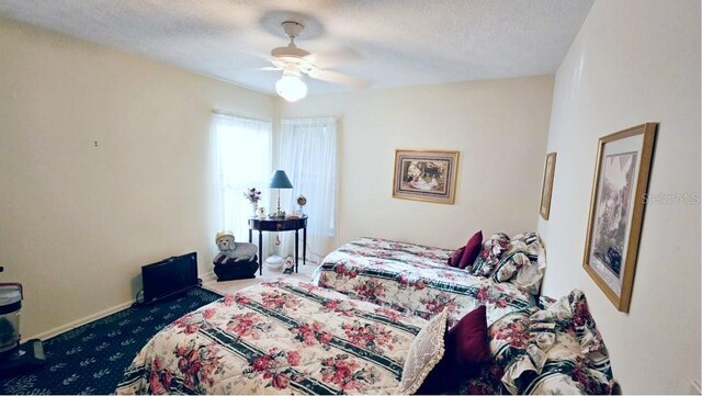 carpeted bedroom with baseboards, a textured ceiling, and a ceiling fan